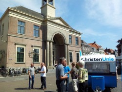 Arie Slob op de Markt in Harderwijk. Op de achtergrond de nieuwe CU-campagnecaravan, die eerder door Arie Slob onthuld werd.